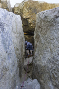 Hiker almost to the top of the fissure on Lawson Peak